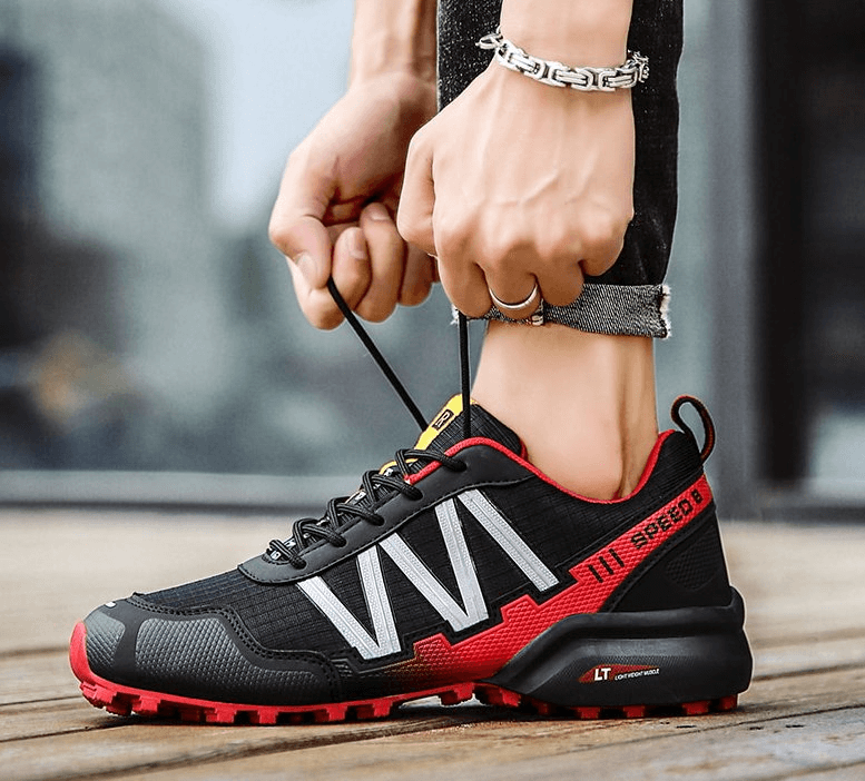 Waterproof non-slip men's sneakers SF0780, black and red design, being tied for a sporty and casual look.